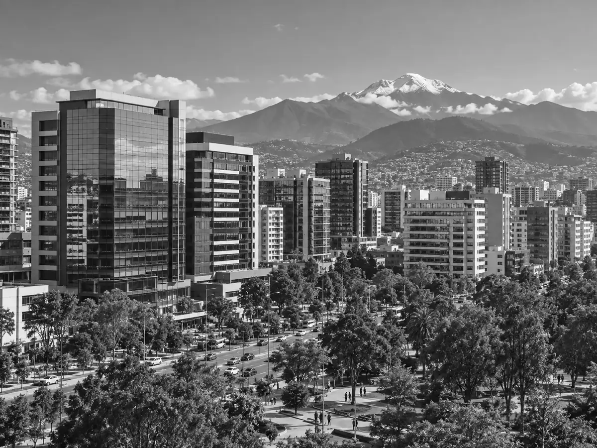 Paisaje urbano con edificios de oficinas y una montaña al fondo.